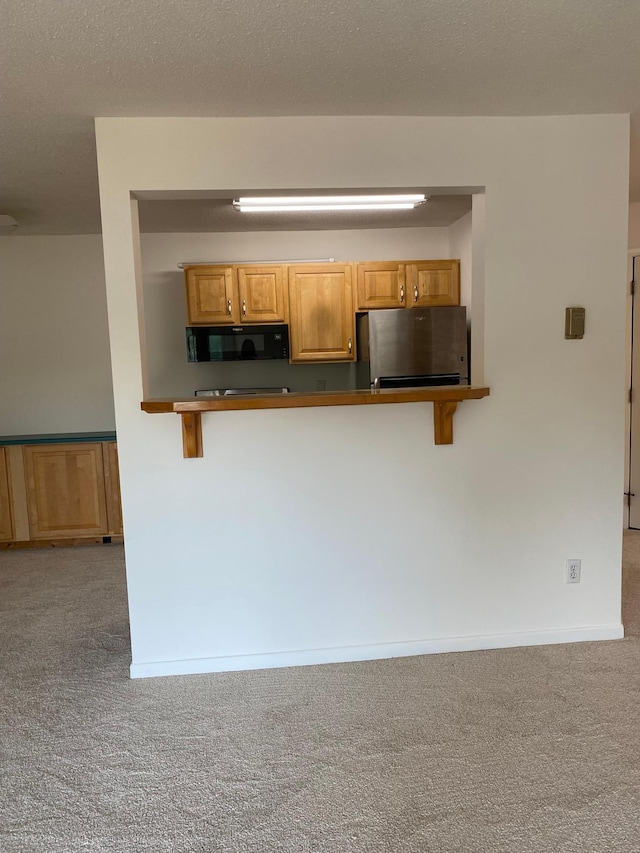 10113 34th St Unit 335, Minnetonka, MN 55305 - kitchen with freestanding refrigerator, carpet floors, black microwave, and a breakfast bar
