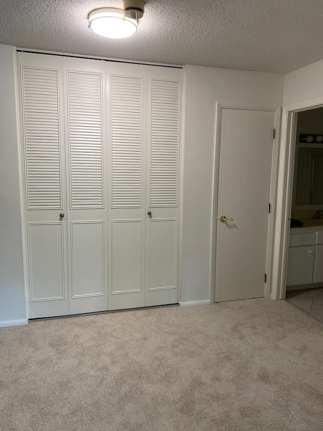 10113 34th St Unit 335, Minnetonka, MN 55305 - unfurnished bedroom with carpet floors, a closet, and a textured ceiling