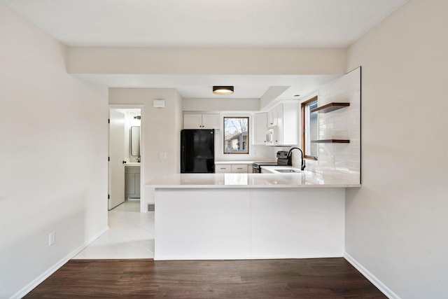 434 11th St Unit D, New Richmond, WI 54017 - kitchen with fridge, stainless steel range with electric cooktop, light countertops, white cabinets, and a peninsula
