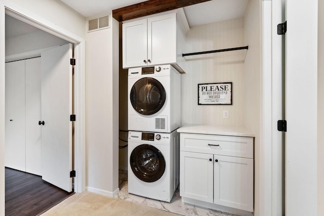 434 11th St Unit D, New Richmond, WI 54017 - laundry area featuring stacked washer / drying machine and cabinet space