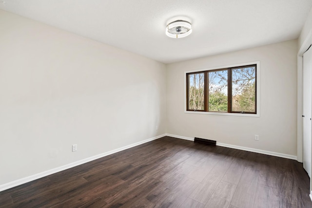 434 11th St Unit D, New Richmond, WI 54017 - unfurnished bedroom with baseboards and dark wood-type flooring