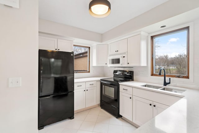 434 11th St Unit D, New Richmond, WI 54017 - kitchen featuring black appliances, white cabinetry, light countertops, and tasteful backsplash