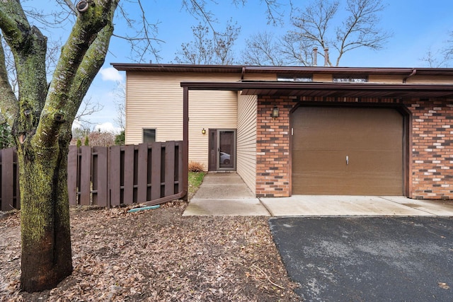 434 11th St Unit D, New Richmond, WI 54017 - view of front of home featuring brick siding, asphalt driveway, and an attached garage