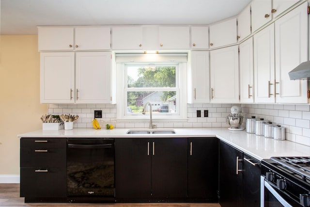 311 Fremont St, River Falls, WI 54022 - kitchen with black appliances, white cabinets, backsplash, light countertops, and dark cabinets