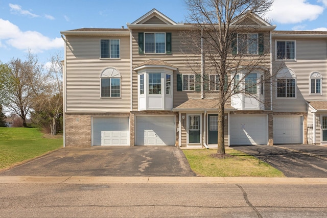 16059 72nd St NE, Otsego, MN 55330 - townhome / multi-family property with driveway, a garage, brick siding, and a front lawn