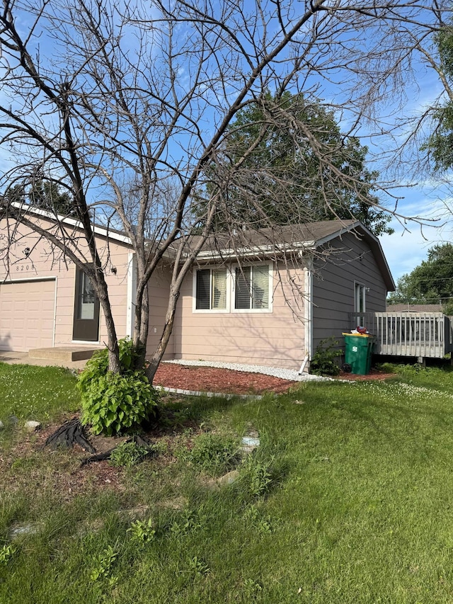 8208 Halifax Ct N, Brooklyn Park, MN 55443 - view of home's exterior featuring a lawn, a deck, and an attached garage