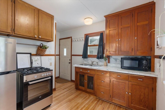 3506 Boardman St, Minneapolis, MN 55417 - kitchen featuring appliances with stainless steel finishes, brown cabinetry, light wood-type flooring, light countertops, and crown molding