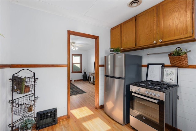 3506 Boardman St, Minneapolis, MN 55417 - kitchen with stainless steel appliances, light wood-style flooring, crown molding, and brown cabinets