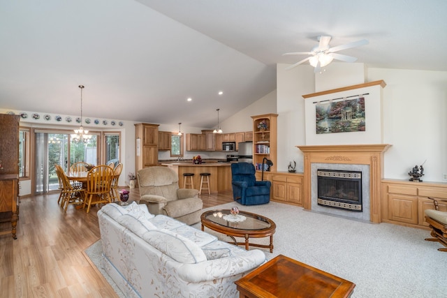 521 Spruce Ln, Crookston, MN 56716 - living room featuring a ceiling fan, light wood-type flooring, a glass covered fireplace, high vaulted ceiling, and a chandelier