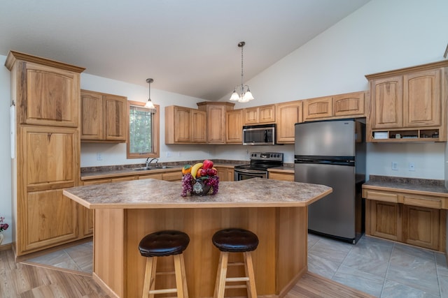 521 Spruce Ln, Crookston, MN 56716 - kitchen with appliances with stainless steel finishes, a kitchen island, a kitchen bar, hanging light fixtures, and high vaulted ceiling