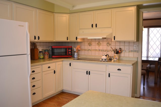 4336 Lookout Ln, Red Wing, MN 55066 - kitchen featuring freestanding refrigerator, extractor fan, black electric cooktop, light countertops, and decorative backsplash
