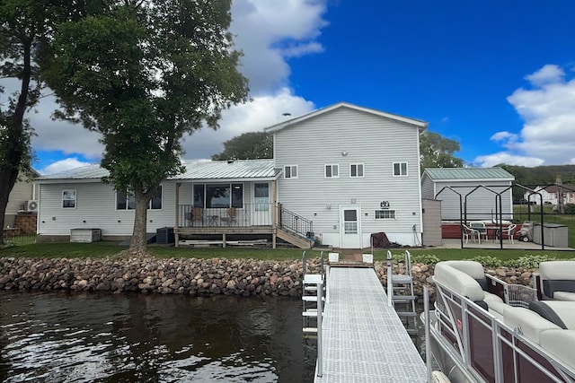 773 US Highway 63, Clayton, WI 54004 - back of property with a water view, a patio area, a metal roof, and a yard