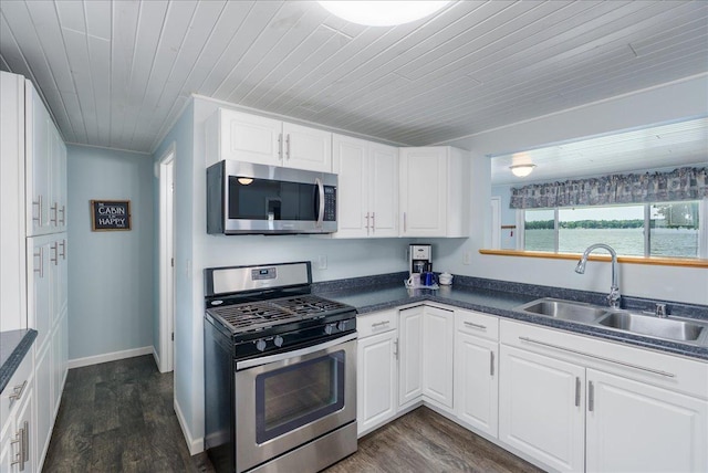 773 US Highway 63, Clayton, WI 54004 - kitchen featuring appliances with stainless steel finishes, dark countertops, dark wood finished floors, wooden ceiling, and white cabinets
