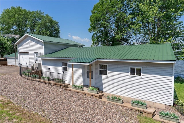 773 US Highway 63, Clayton, WI 54004 - view of front facade with a vegetable garden, a metal roof, an outbuilding, and a garage