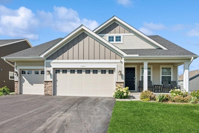 2051 Diamond Ln, Lino Lakes, MN 55038 - craftsman house with an attached garage, board and batten siding, covered porch, driveway, and stone siding