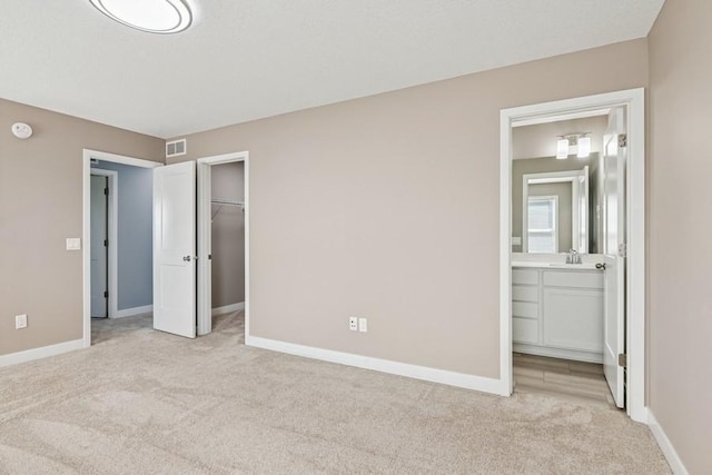 2051 Diamond Ln, Lino Lakes, MN 55038 - unfurnished bedroom featuring light carpet, ensuite bathroom, a spacious closet, and a closet