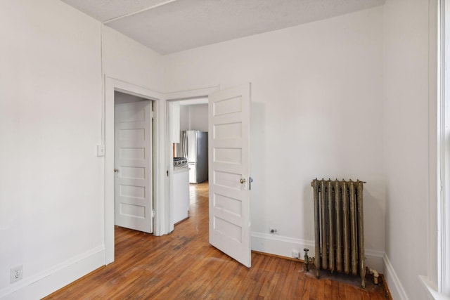 104 27th St, Minneapolis, MN 55408 - spare room featuring radiator and hardwood / wood-style floors
