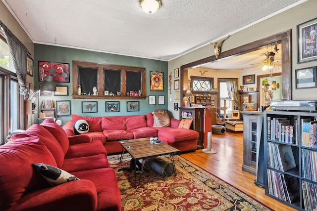 104 27th St, Minneapolis, MN 55408 - living room with wood finished floors, crown molding, a textured ceiling, and a ceiling fan