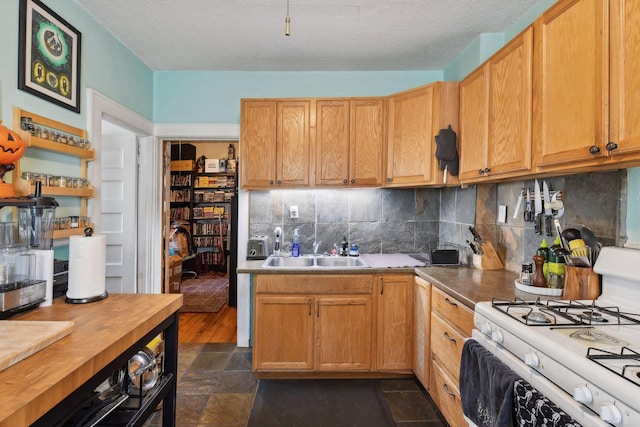 104 27th St, Minneapolis, MN 55408 - kitchen with white gas range oven, decorative backsplash, a textured ceiling, and dark stone finish floors