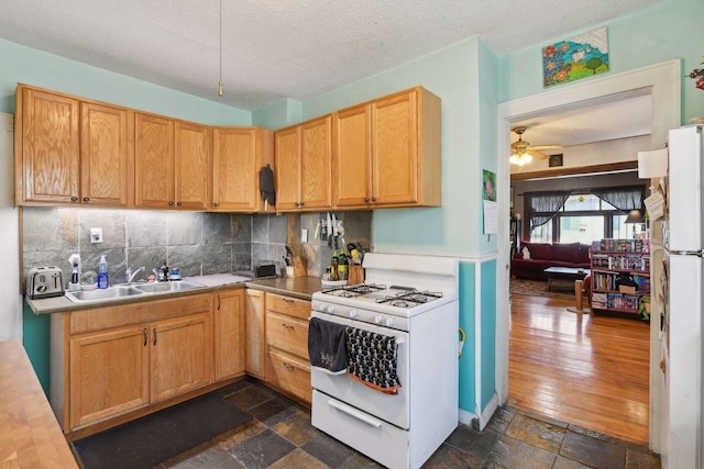104 27th St, Minneapolis, MN 55408 - kitchen with white appliances, decorative backsplash, stone tile floors, a textured ceiling, and ceiling fan
