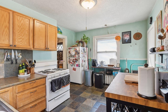 104 27th St, Minneapolis, MN 55408 - kitchen featuring white appliances, tasteful backsplash, a textured ceiling, and stone finish floors
