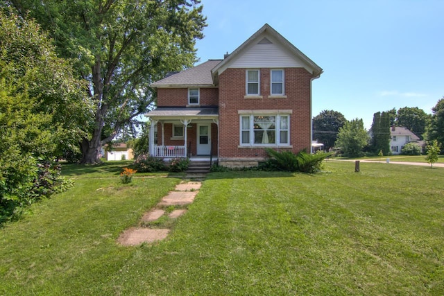 735 Broadway Ave, Wabasha, MN 55981 - view of front of house with brick siding, a porch, and a front yard