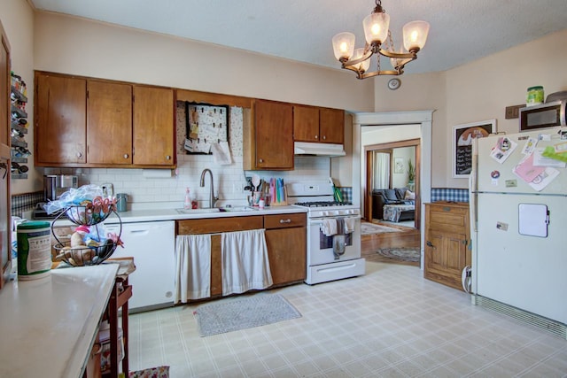 735 Broadway Ave, Wabasha, MN 55981 - kitchen featuring white appliances, brown cabinets, under cabinet range hood, light countertops, and a chandelier