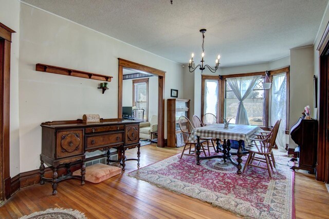 735 Broadway Ave, Wabasha, MN 55981 - dining space featuring light wood finished floors, a chandelier, and a textured ceiling