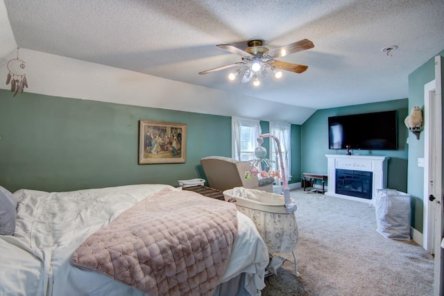 735 Broadway Ave, Wabasha, MN 55981 - bedroom featuring lofted ceiling, carpet flooring, a glass covered fireplace, a textured ceiling, and a ceiling fan