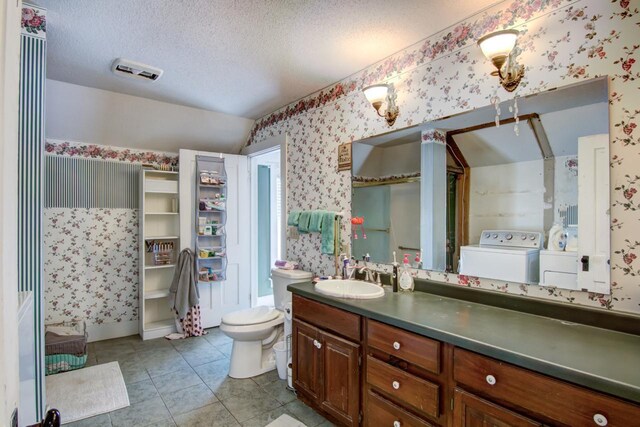 735 Broadway Ave, Wabasha, MN 55981 - bathroom featuring wallpapered walls, washing machine and dryer, vanity, tile patterned floors, and a textured ceiling