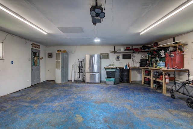 735 Broadway Ave, Wabasha, MN 55981 - garage featuring freestanding refrigerator, a workshop area, a wall mounted AC, and a garage door opener