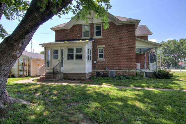 735 Broadway Ave, Wabasha, MN 55981 - rear view of property featuring entry steps, a lawn, covered porch, and brick siding