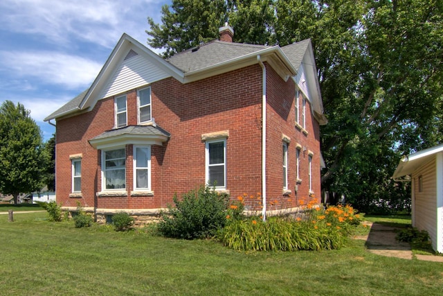 735 Broadway Ave, Wabasha, MN 55981 - view of home's exterior with brick siding, a chimney, a yard, and a shingled roof