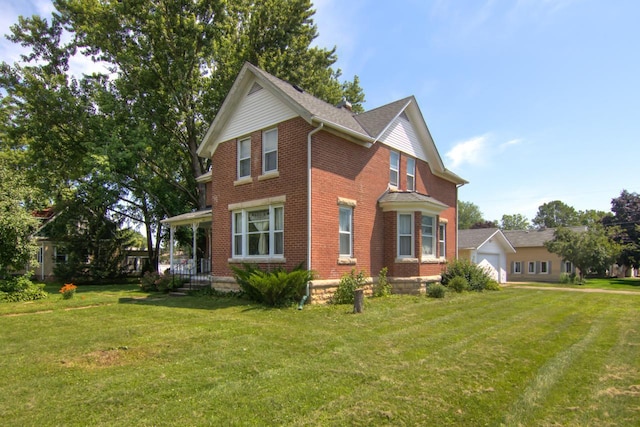 735 Broadway Ave, Wabasha, MN 55981 - view of front facade with brick siding, a front yard, and a detached garage