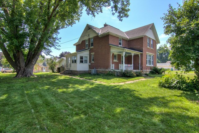 735 Broadway Ave, Wabasha, MN 55981 - view of property exterior with brick siding, a porch, and a lawn