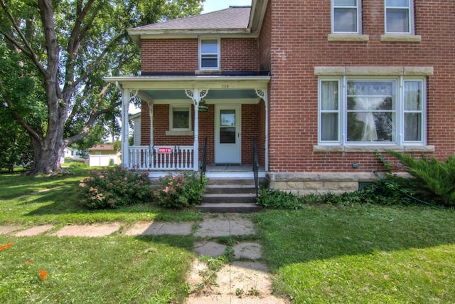 735 Broadway Ave, Wabasha, MN 55981 - view of front of home with brick siding, a front lawn, and a porch