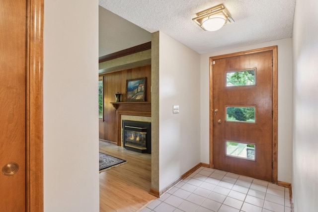 3748 Hilltop Rd, Minnetonka, MN 55305 - foyer with a glass covered fireplace, a textured ceiling, and light tile patterned floors