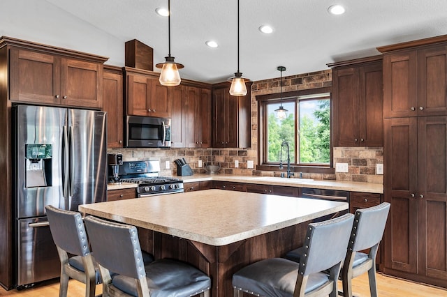 22493 Carina Ct, Farmington, MN 55024 - kitchen with stainless steel appliances, a breakfast bar, tasteful backsplash, light countertops, and recessed lighting