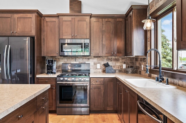 22493 Carina Ct, Farmington, MN 55024 - kitchen featuring stainless steel appliances, light countertops, backsplash, pendant lighting, and vaulted ceiling
