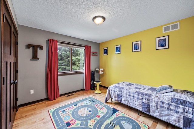 22493 Carina Ct, Farmington, MN 55024 - bedroom with wood finished floors and a textured ceiling
