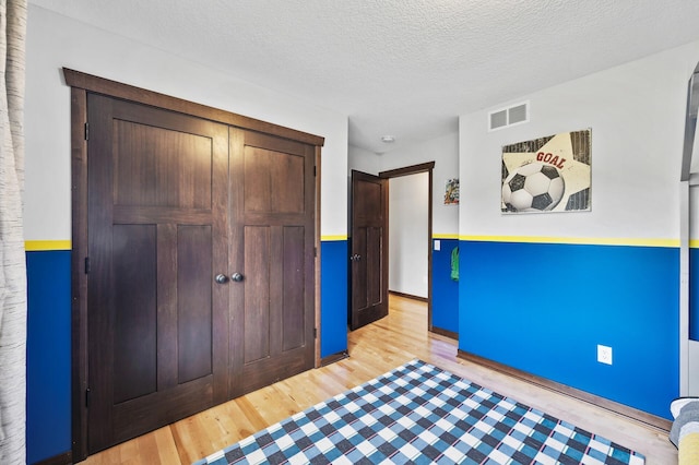 22493 Carina Ct, Farmington, MN 55024 - unfurnished bedroom with light wood-type flooring, a textured ceiling, and a closet