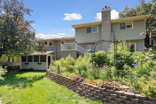 4011 Grimes Ave S, Edina, MN 55416 - rear view of house with a chimney, a lawn, and a sunroom