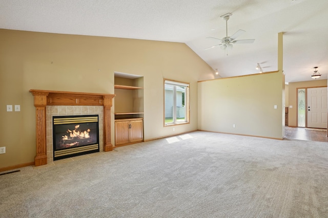 343 Tuttle Dr, Hastings, MN 55033 - unfurnished living room featuring a ceiling fan, light carpet, a tiled fireplace, and lofted ceiling