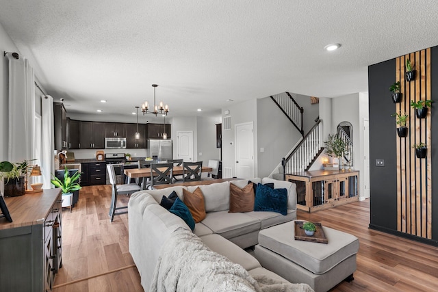 1174 139th St E, Rosemount, MN 55068 - living area with a chandelier, light wood-style flooring, stairs, a textured ceiling, and recessed lighting