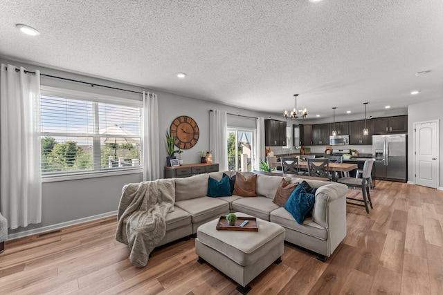 1174 139th St E, Rosemount, MN 55068 - living area featuring a chandelier, a textured ceiling, light wood-style floors, and recessed lighting
