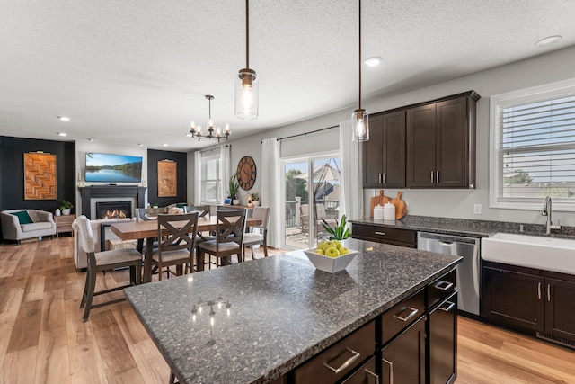 1174 139th St E, Rosemount, MN 55068 - kitchen featuring dishwasher, a textured ceiling, dark brown cabinets, a warm lit fireplace, and light wood finished floors