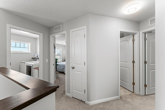 1174 139th St E, Rosemount, MN 55068 - corridor featuring separate washer and dryer, light colored carpet, and a textured ceiling