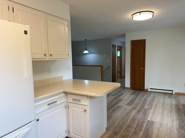 240 12th Ave, Grand Rapids, MN 55744 - kitchen featuring freestanding refrigerator, a baseboard radiator, a peninsula, and white cabinets