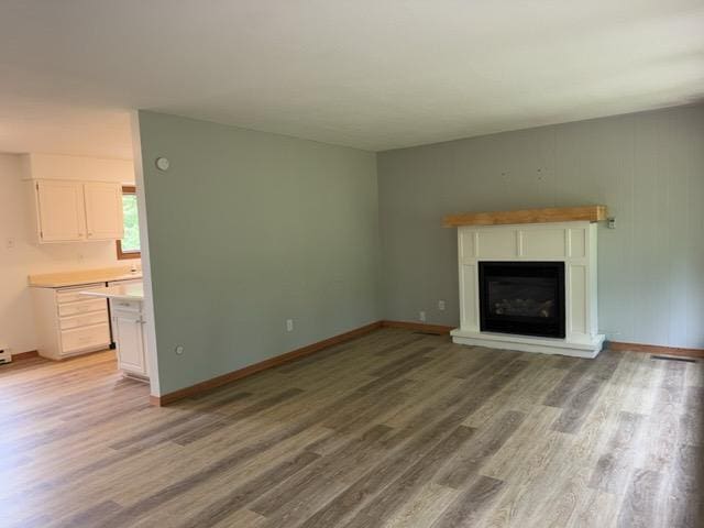 240 12th Ave, Grand Rapids, MN 55744 - unfurnished living room featuring light wood-type flooring and a glass covered fireplace