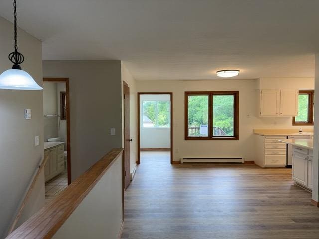 240 12th Ave, Grand Rapids, MN 55744 - unfurnished dining area with baseboard heating, healthy amount of natural light, and light wood finished floors
